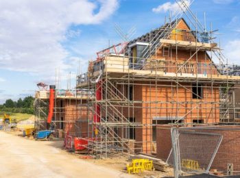 Scaffolding surrounding new homes during building on a housing estate near Milton Keynes, north of London, UK.